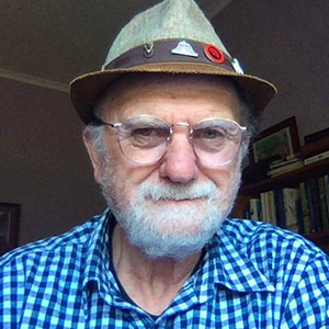 The man with badges on his cap