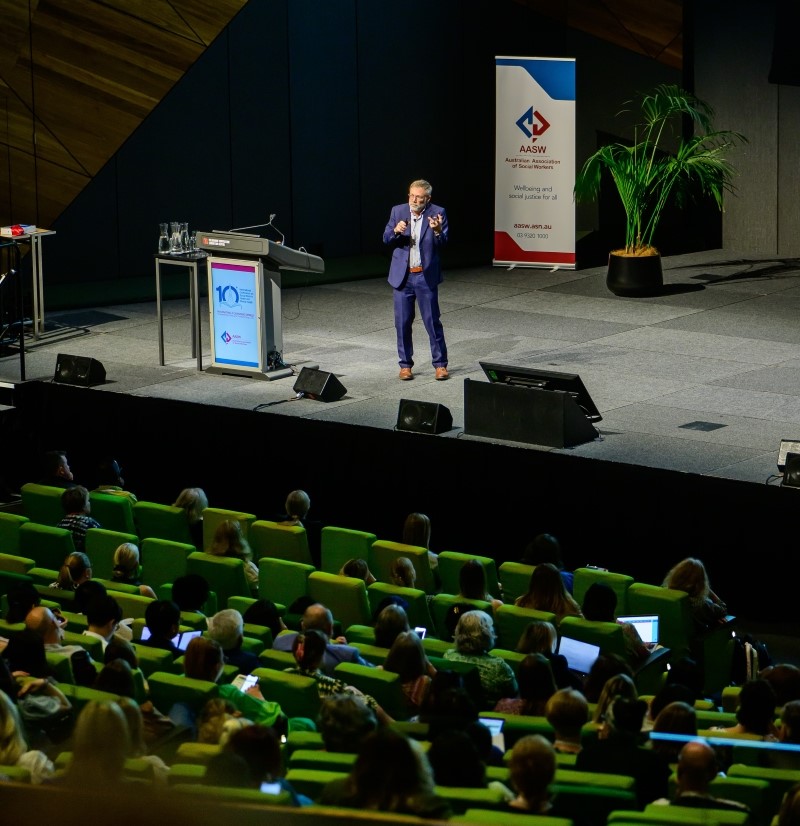 Group photo of lived-experience advocates and policymakers on stage